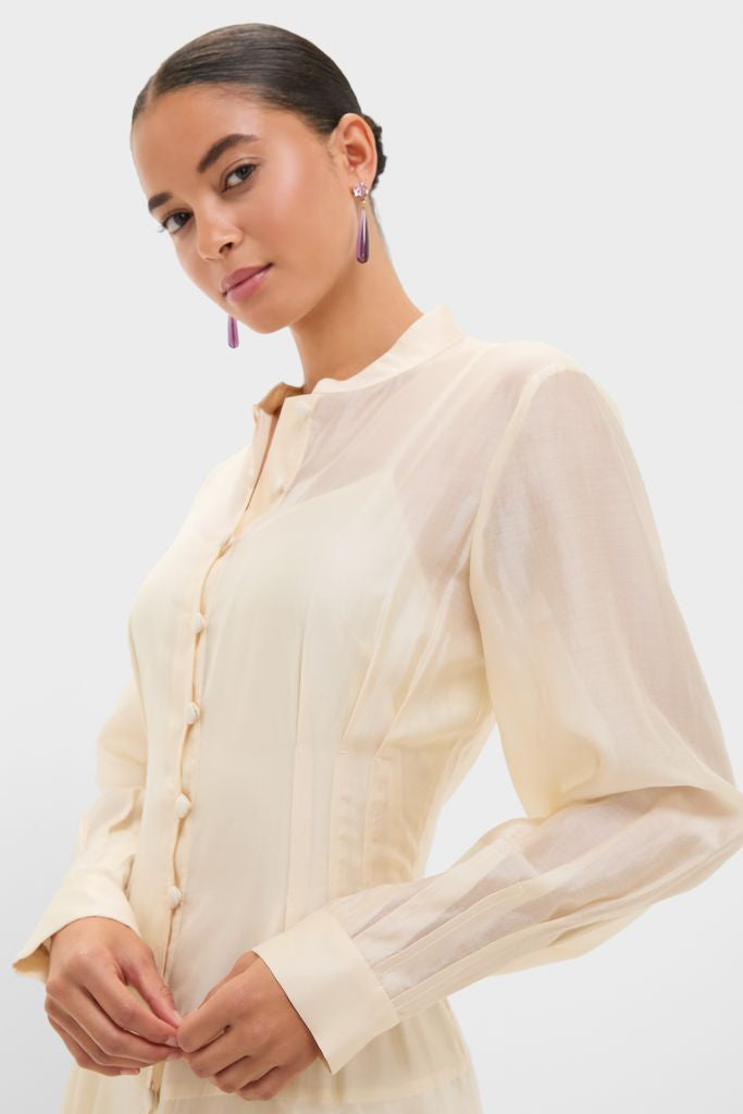 The Champagne Organza Marbella Dress exudes effortless elegance with its classic mandarin collar, sheer pleated sleeves, and high-end details, perfect for fun, sophisticated occasions.