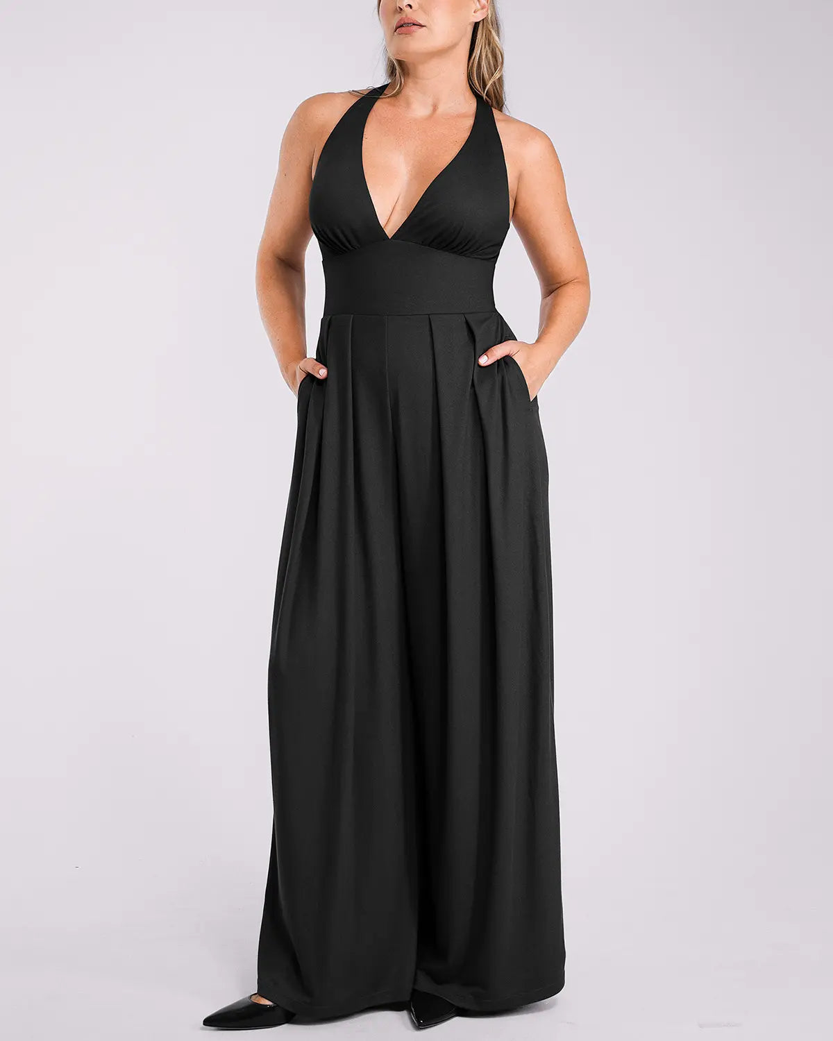 Model wearing deep V jumpsuit with built-in shaping support and flattering silhouette