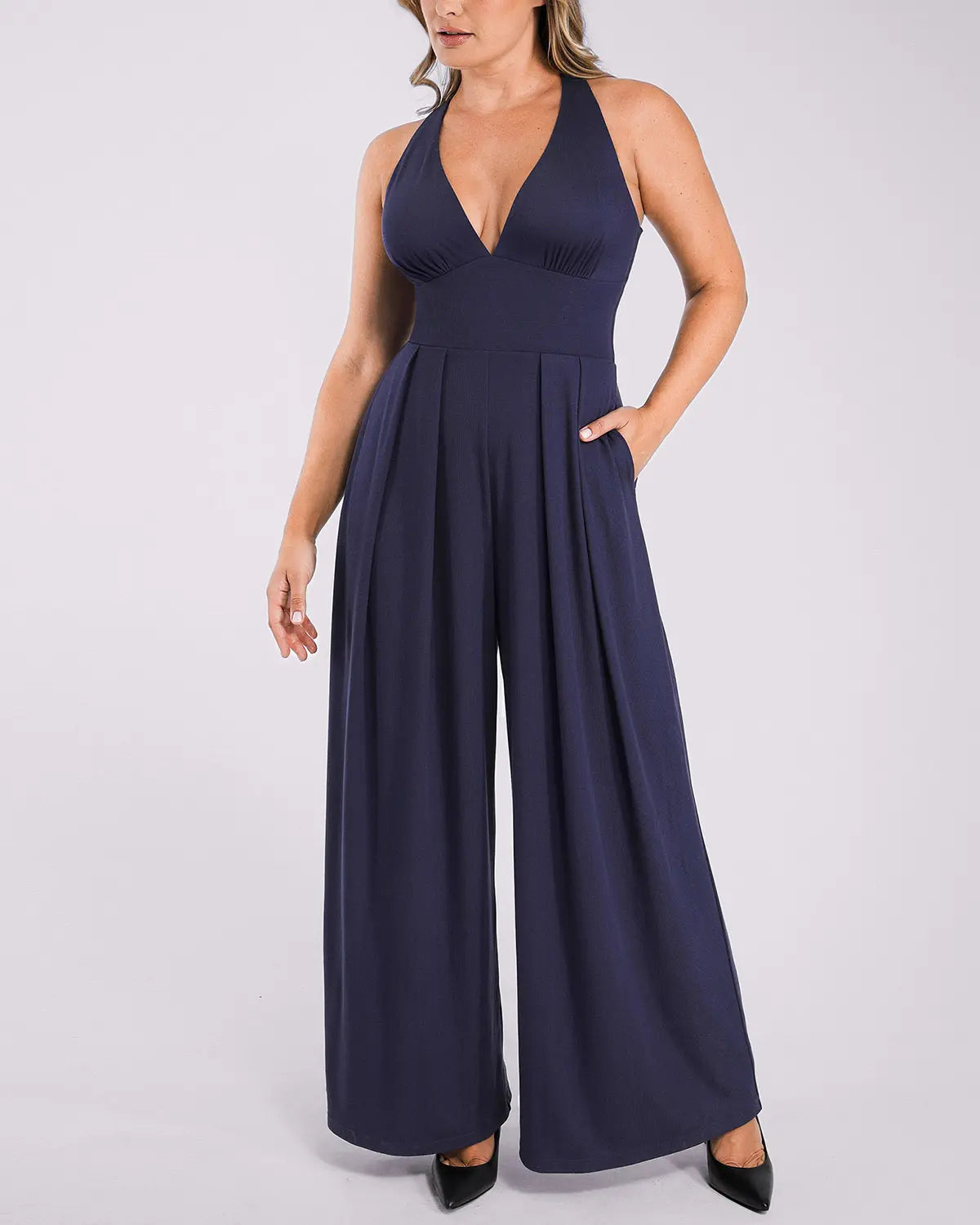 Model wearing deep V jumpsuit with built-in shaping support and flattering silhouette